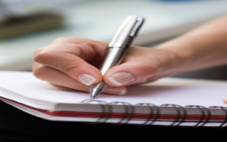 Woman Writing in Notepad